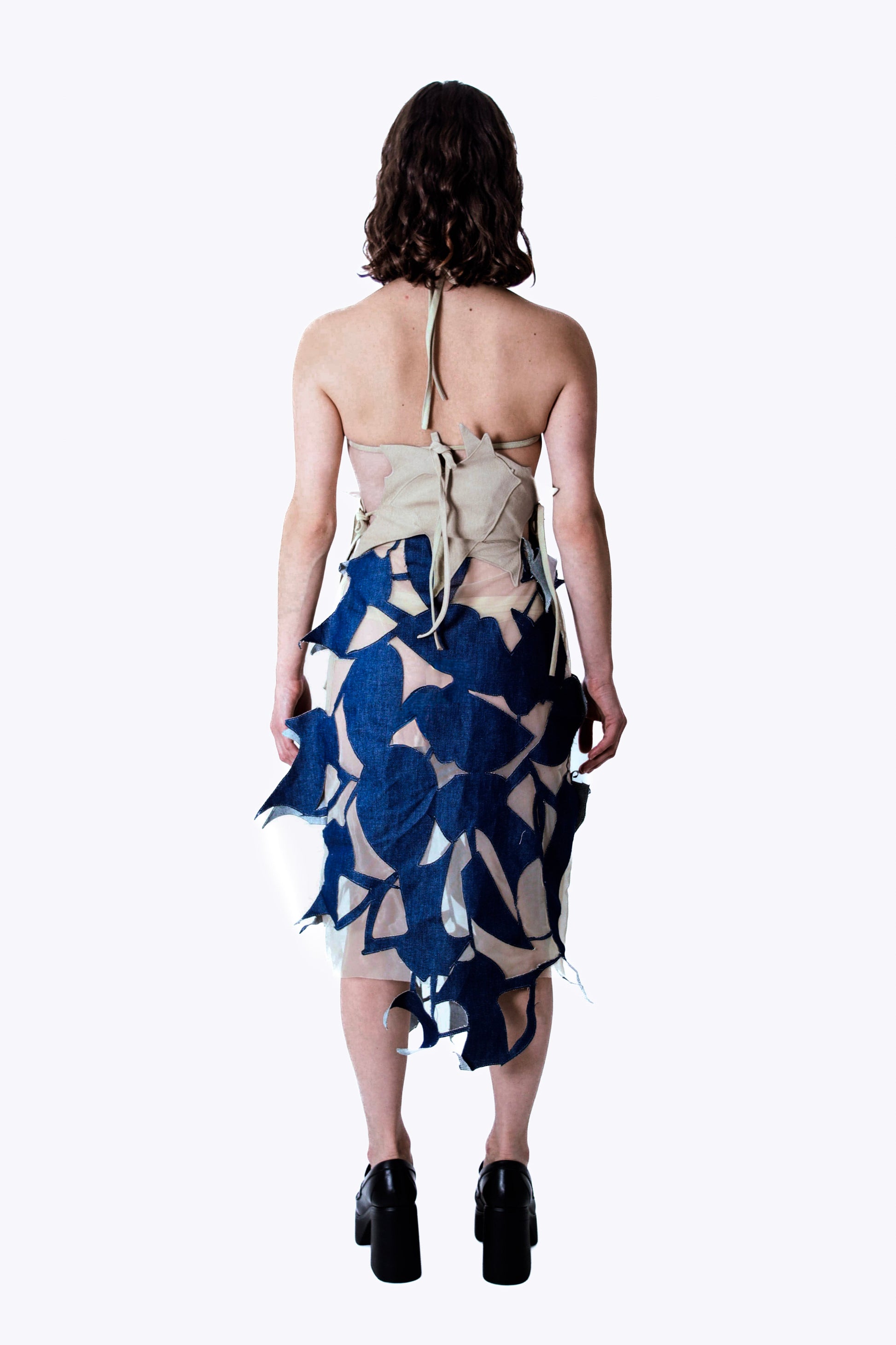 Woman wearing a dress with a blue and beige pattern on a white background