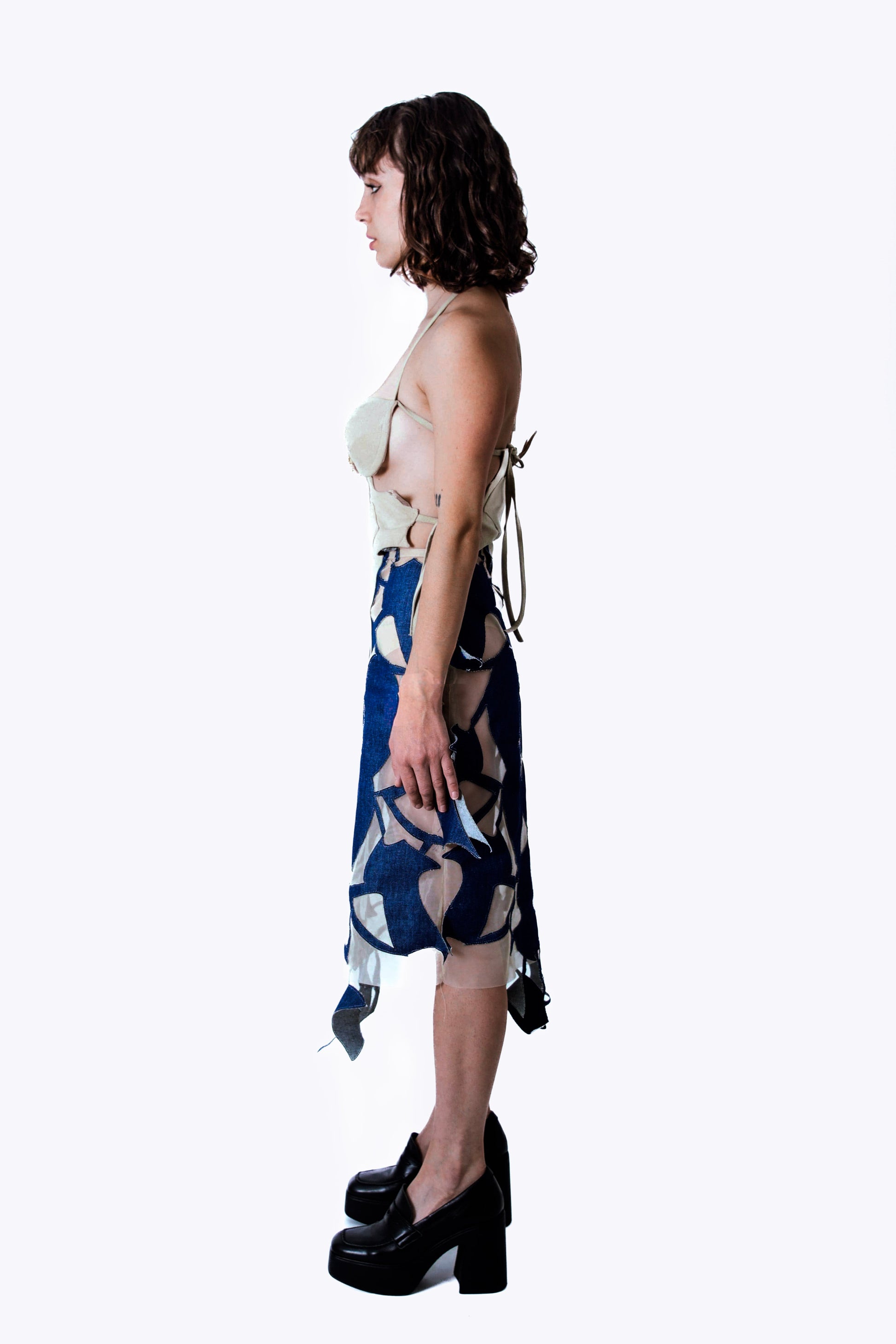 Woman wearing a blue denim dress with a white background