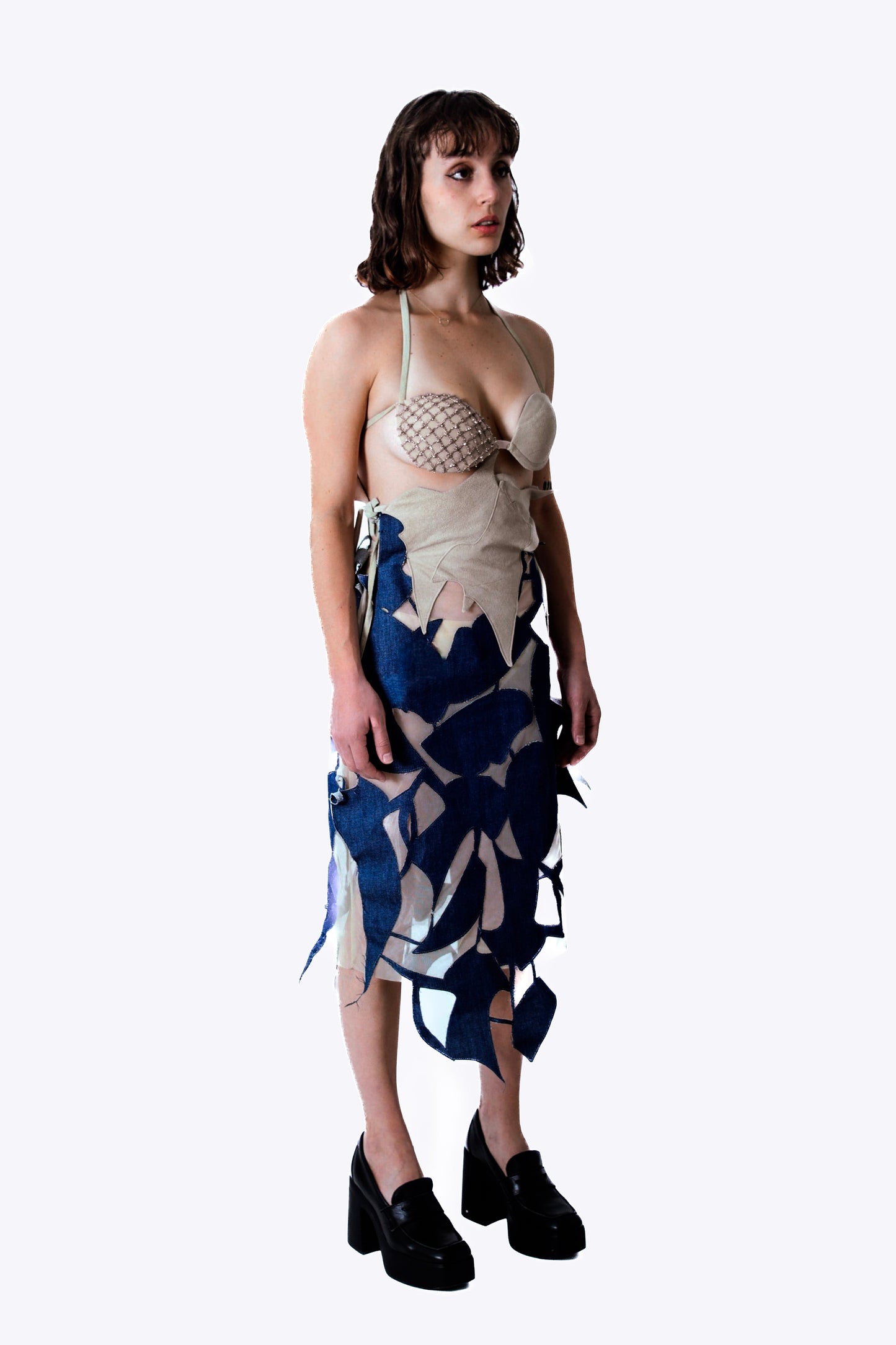 Woman wearing a beige dress with a denim pattern on a white background