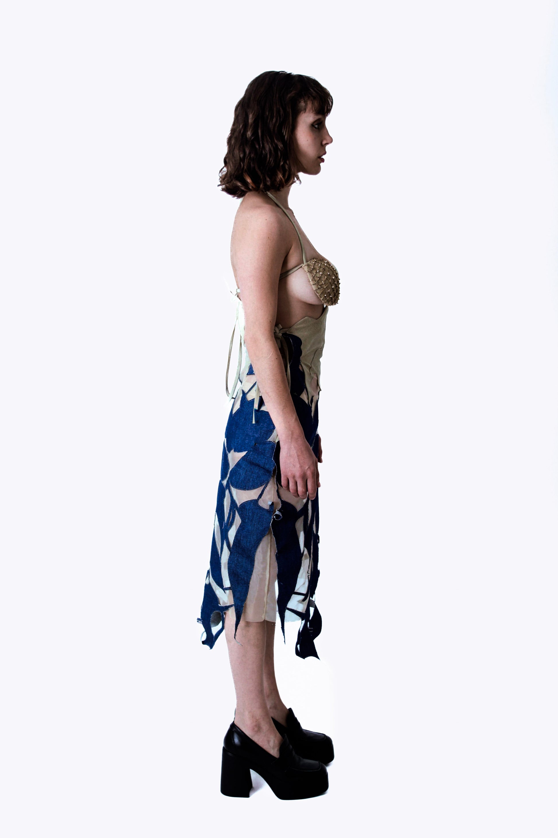 Woman wearing a denim dress with a white background