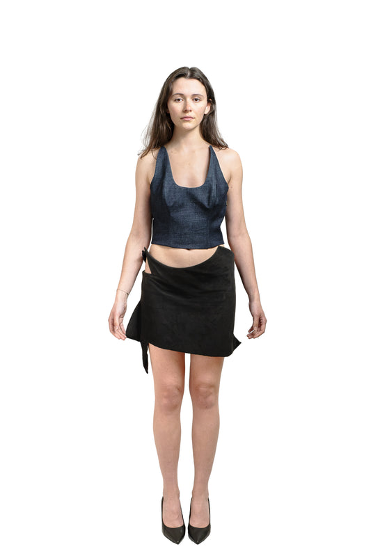 Black suede mini skirt with cutout waistband and asymmetric tie detail, worn with a denim crop top